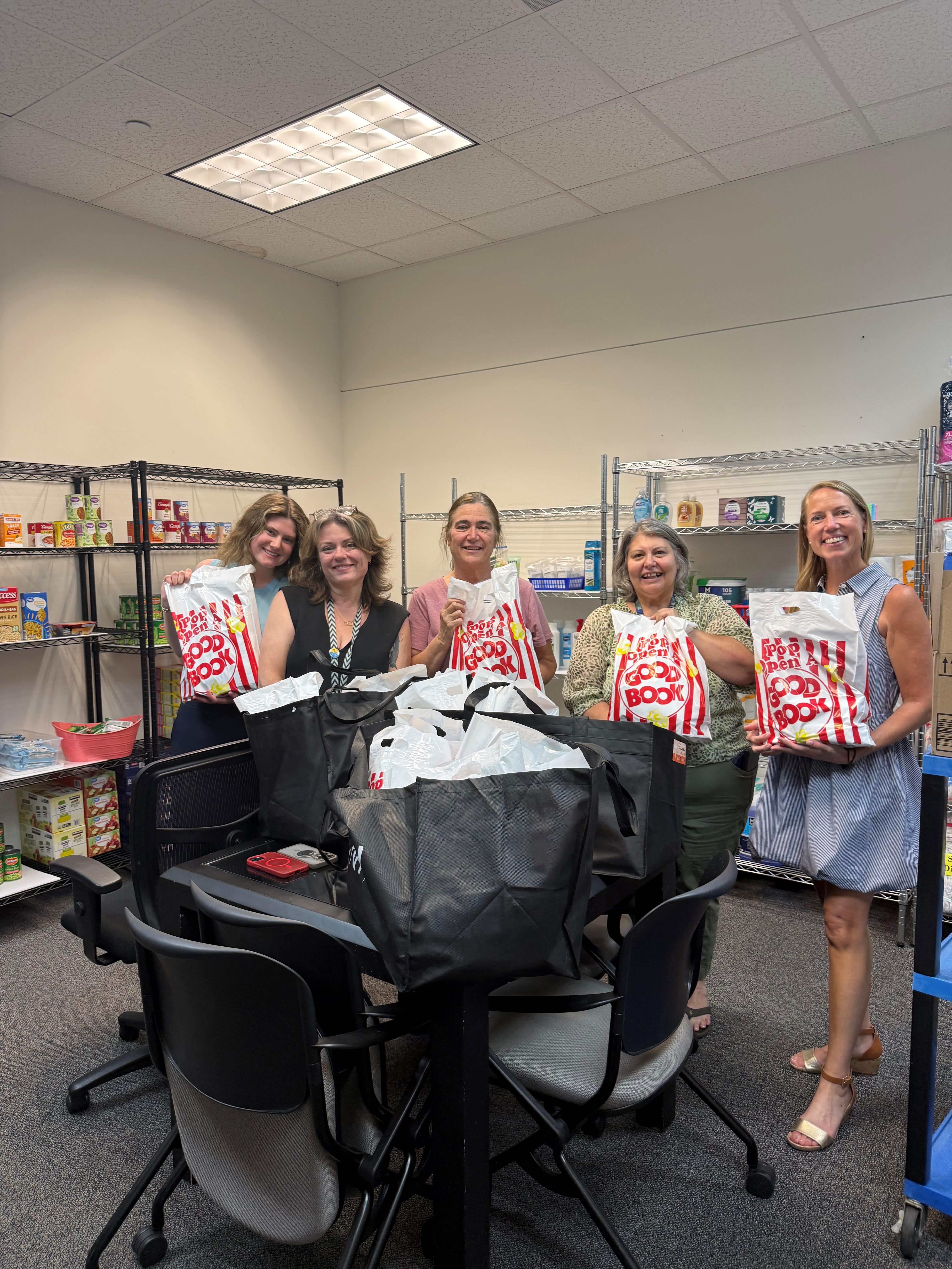 five women smiling holding the bags